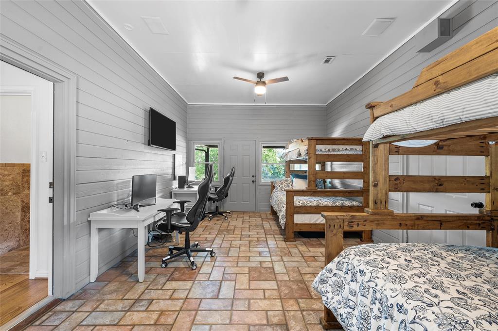 1396 Eagle Canyon Drive China Spring, TX 76633 - Photo 20 of 40 Bedroom with an office area, wood walls, and brick floors