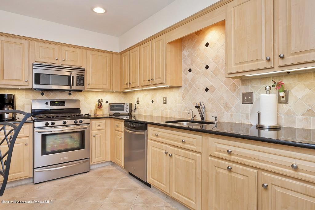 104 Racquet Road Wall, NJ 07719 - Photo 1 of 26 a kitchen with granite countertop white cabinets and stainless steel appliances