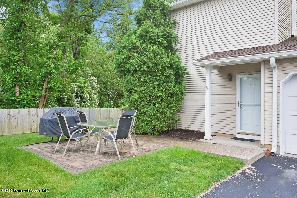 104 Racquet Road Wall, NJ 07719 - Photo 4 of 26 a view of a patio with table and chairs and wooden fence