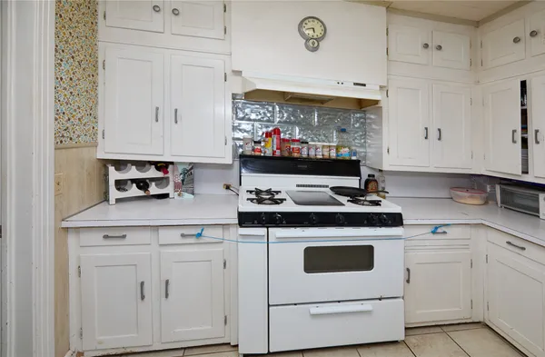 a kitchen with white cabinets and white appliances