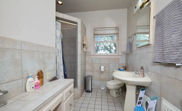 a bathroom with a sink toilet and a mirror