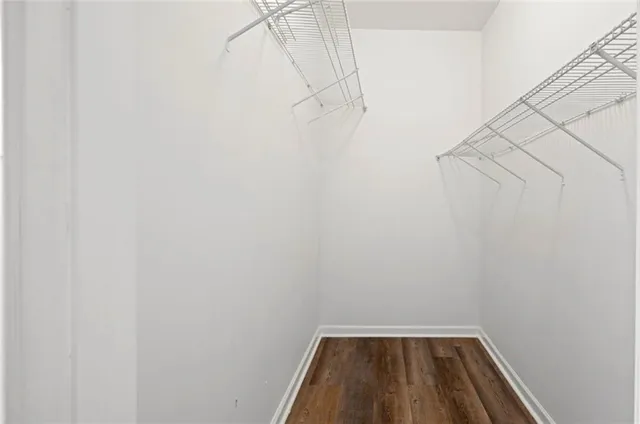 a view of walk in closet with clothes and shoes