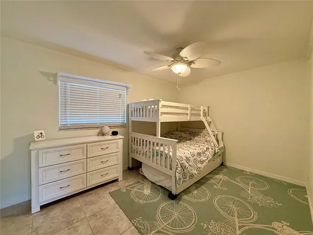 a bedroom with a bed and a ceiling fan