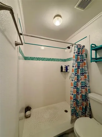 a bathroom with a shower a toilet and sink