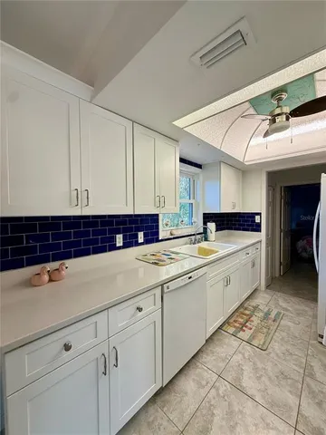 a kitchen with kitchen island granite countertop a sink and cabinets