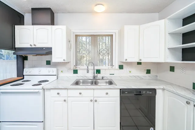 a kitchen with stainless steel appliances a stove a sink and a refrigerator