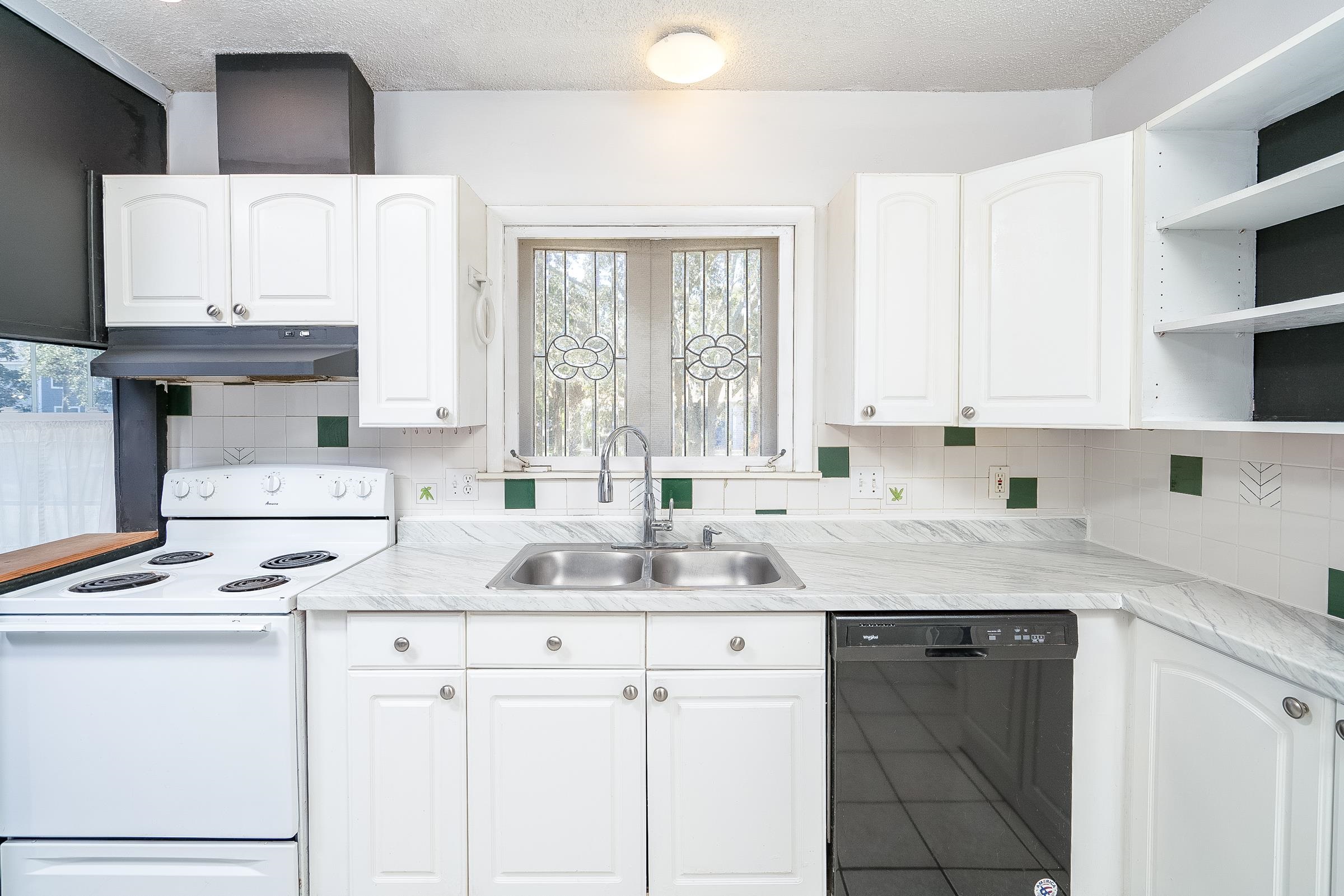 401 Zorayda Avenue St. Augustine, FL 32080 - Photo 15 of 41 a kitchen with granite countertop a sink stove and white cabinets