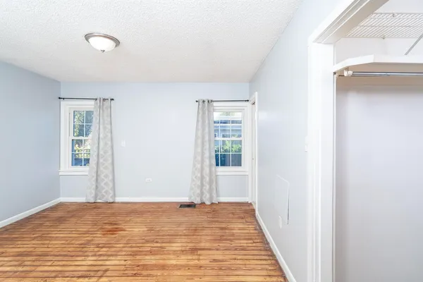 a view of a room with wooden floor and a bathroom