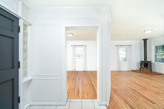 a view of a bedroom with wooden floor and windows
