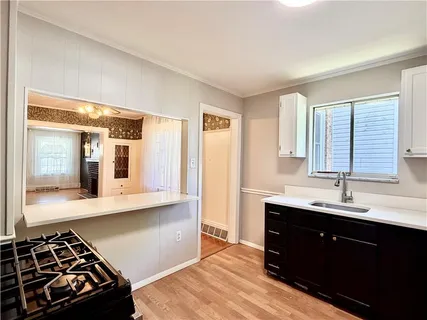 a kitchen with stainless steel appliances a sink stove and cabinets