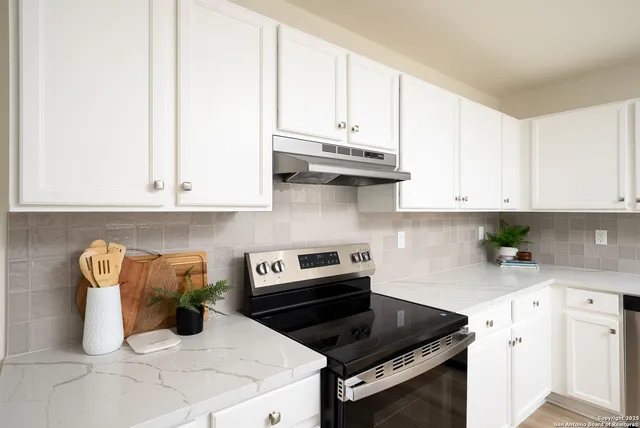 a kitchen with white cabinets and appliances