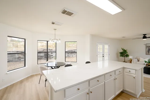 a large white kitchen with a large window