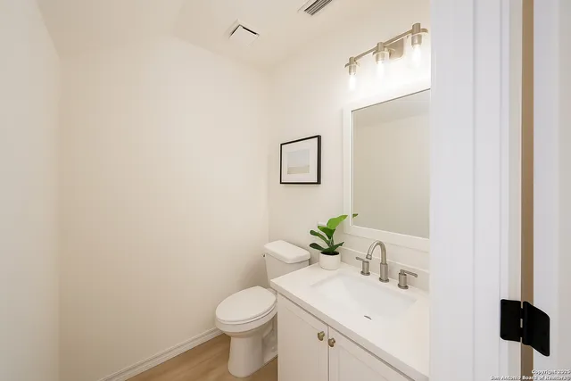 a bathroom with a sink vanity mirror and toilet
