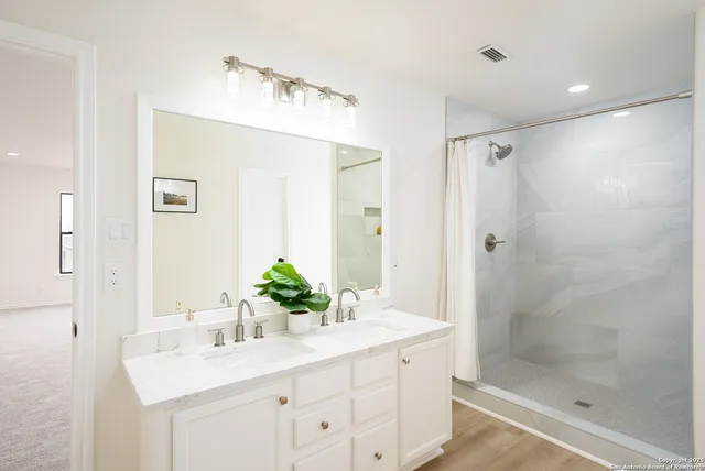 a bathroom with a shower sink and mirror