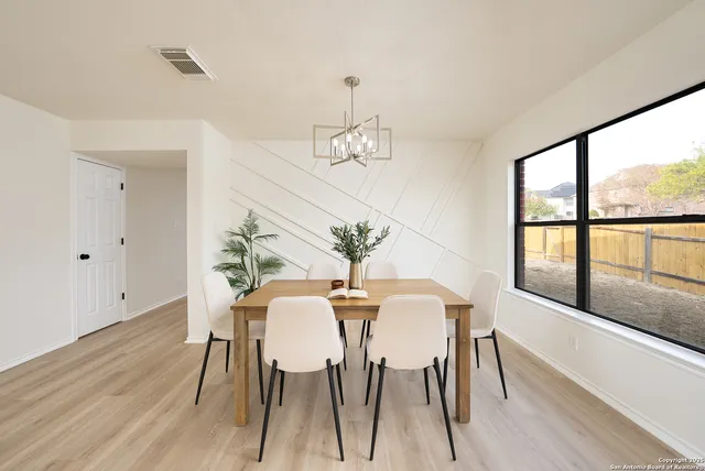 a view of a dining room with furniture a chandelier and wooden floor