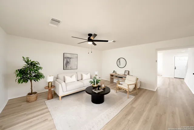 a living room with furniture and a potted plant