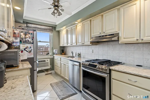 a kitchen with stainless steel appliances granite countertop a stove a sink and a refrigerator