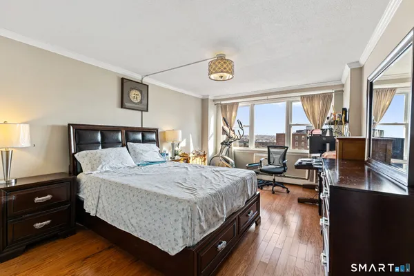 a bedroom with a bed and wooden floor