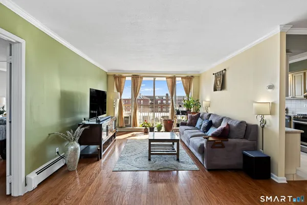 a living room with furniture a flat screen tv and a large window
