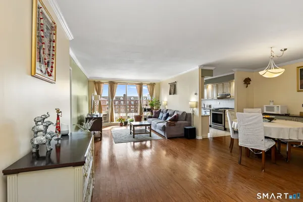 a living room with furniture dining area and a wooden floor