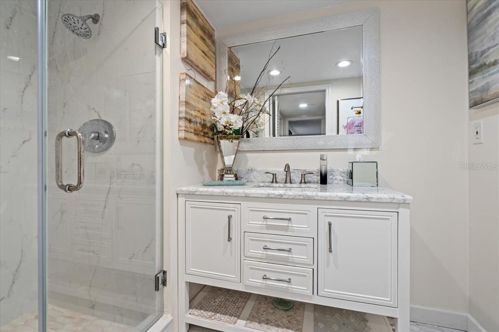 100 Southeast 5th Avenue, Unit 412 Boca Raton, FL 33432 - Photo 31 of 62 a bathroom with a granite countertop sink a mirror and a shower