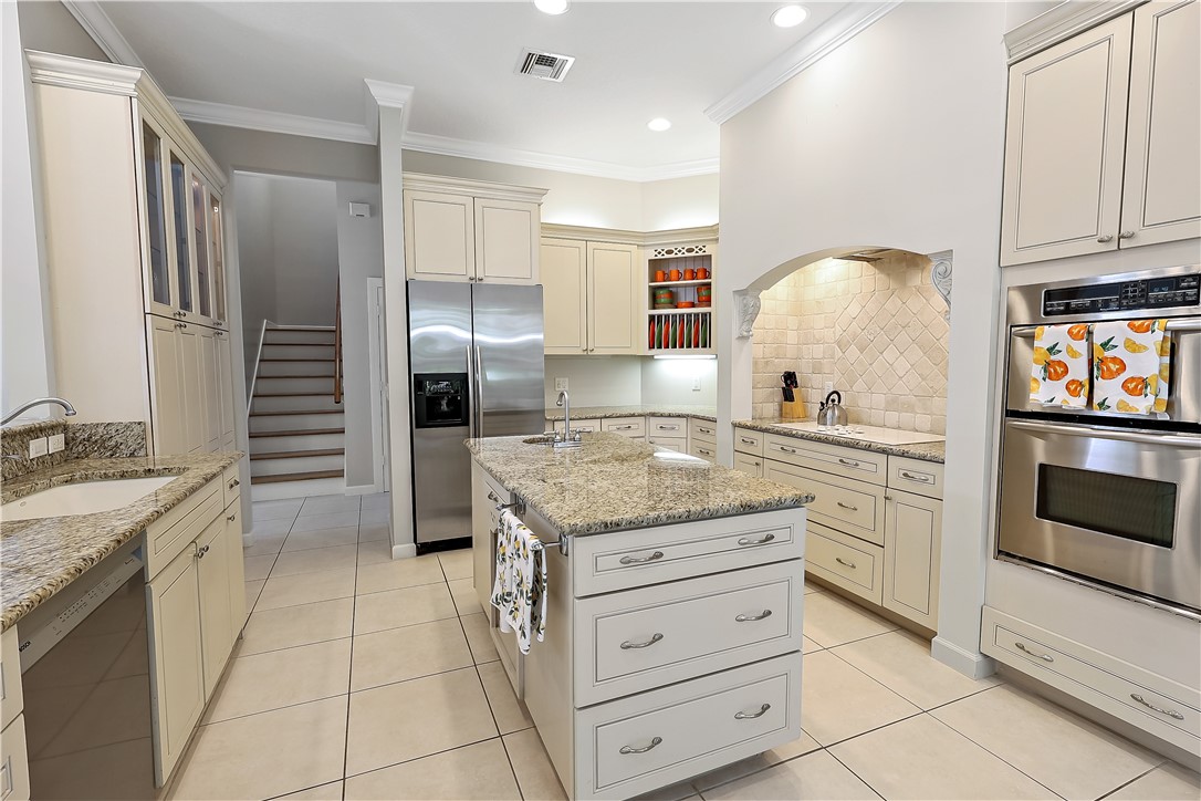 2038 Ocean Ridge Circle Vero Beach, FL 32963 - Photo 11 of 33 a kitchen with granite countertop a stove and a refrigerator