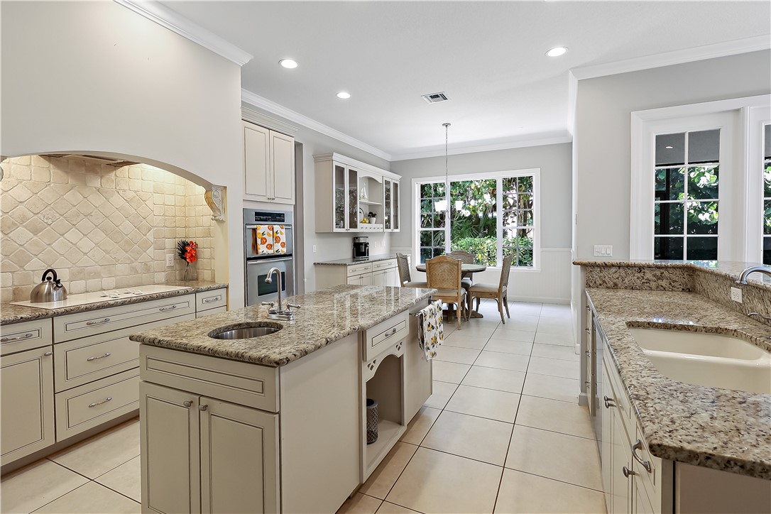2038 Ocean Ridge Circle Vero Beach, FL 32963 - Photo 12 of 33 a kitchen with stainless steel appliances granite countertop a sink stove and cabinets