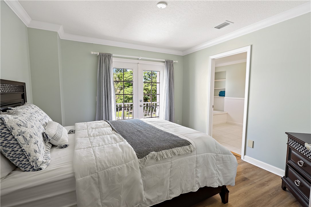 2038 Ocean Ridge Circle Vero Beach, FL 32963 - Photo 30 of 33 a bedroom with a bed and wooden floor