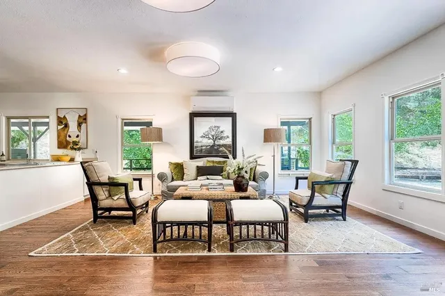 a living room with furniture kitchen view and a large window
