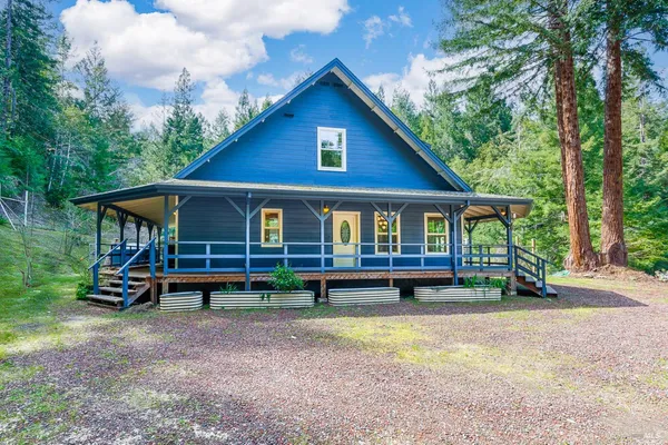 a view of front of a house with a yard table and chairs