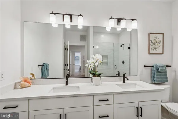 a bathroom with double vanity sinks and a mirror
