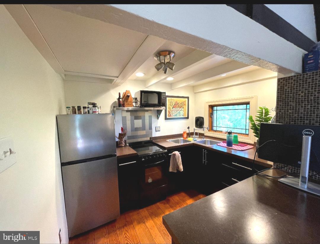 1451 Walton Road, Unit B Blue Bell, PA 19422 - Photo 8 of 12 a kitchen with stainless steel appliances granite countertop a refrigerator a sink dishwasher a stove and a dining table with wooden floor