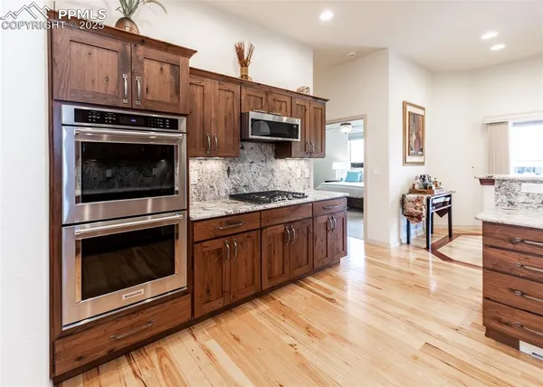 a kitchen with stainless steel appliances kitchen island granite countertop a stove cabinets and microwave