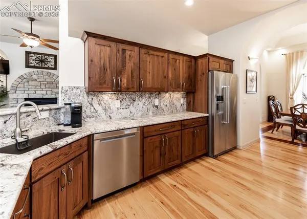 a kitchen with stainless steel appliances granite countertop wooden cabinets a stove top oven a sink and dishwasher