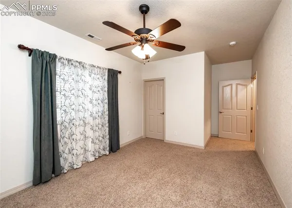 an empty room with fan and closet