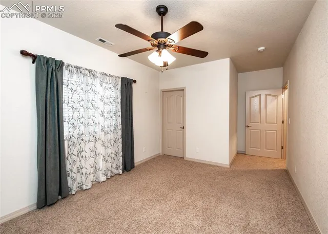an empty room with fan and closet