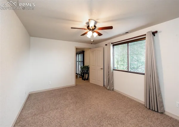 a view of a livingroom with a ceiling fan and window