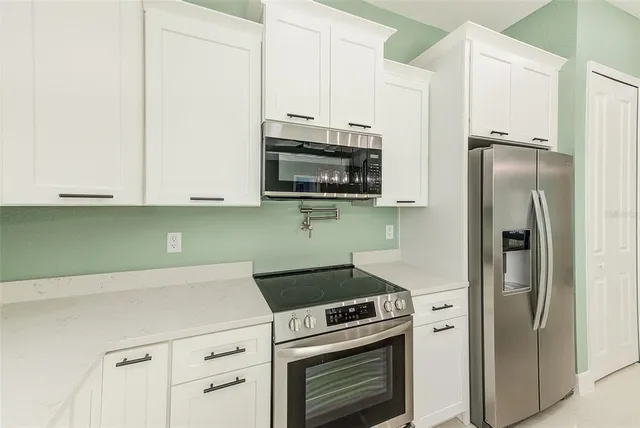 a kitchen with stainless steel appliances white cabinets and a stove
