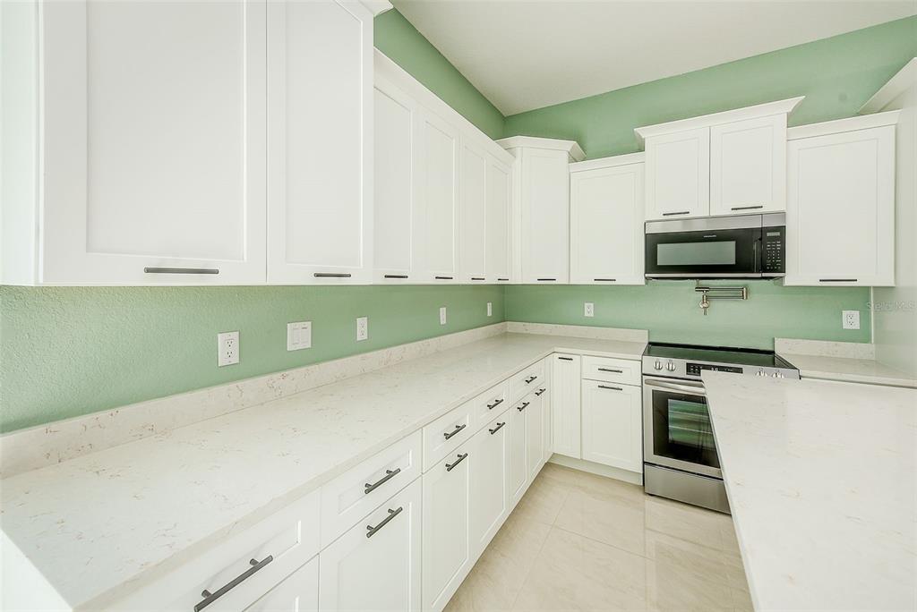 11111 Hackney Drive Riverview, FL 33578 - Photo 14 of 40 a kitchen with granite countertop white cabinets and stainless steel appliances