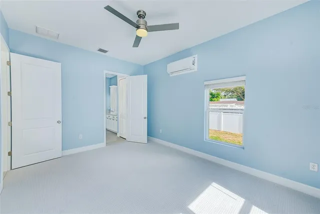 an empty room with window and ceiling fan