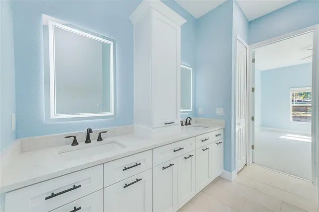 a bathroom with double sink and a mirror