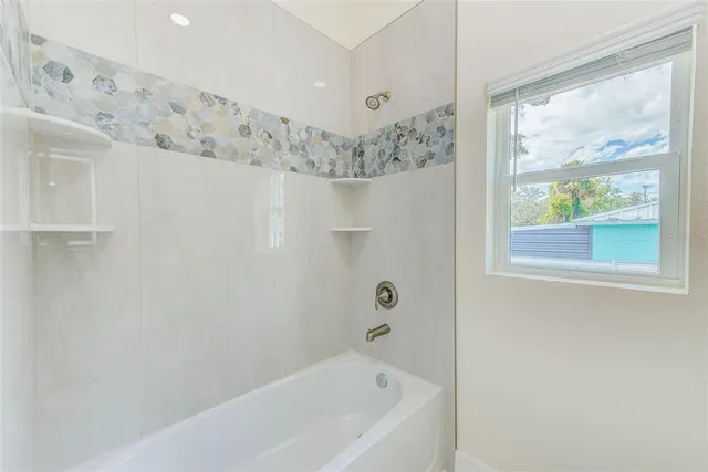 a bathroom with a bathtub and window