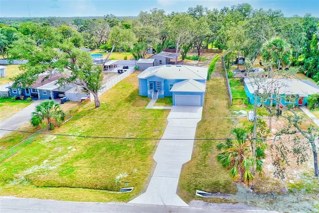 a aerial view of a house with swimming pool and large trees