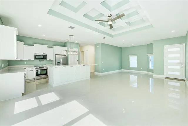 a view of a kitchen with kitchen island a sink stainless steel appliances and cabinets