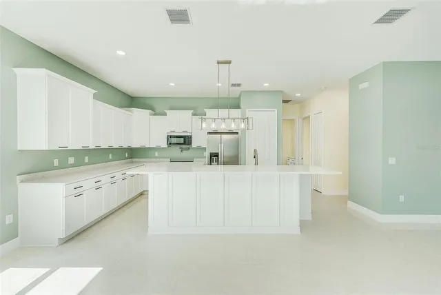 a kitchen with white cabinets and white appliances