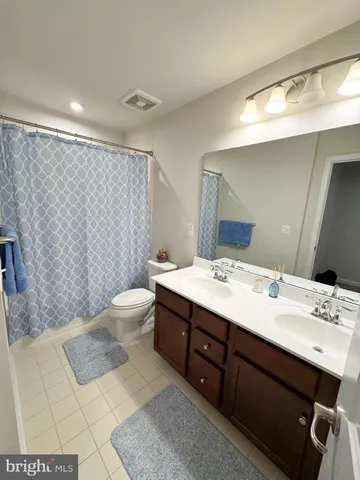 a bathroom with a sink a toilet a mirror and shower