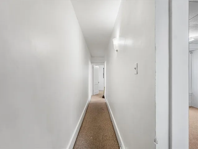a view of empty room with window and refrigerator