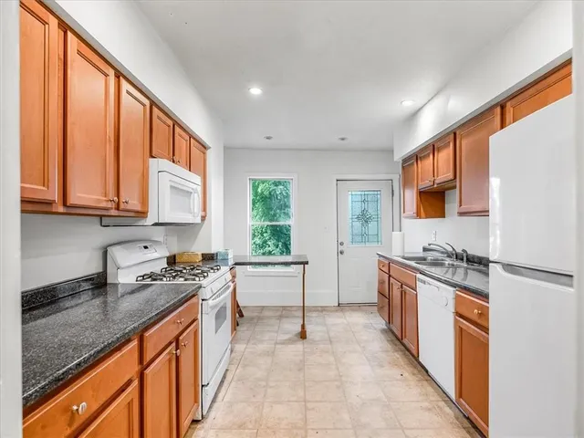a kitchen with stainless steel appliances granite countertop a sink stove and cabinets