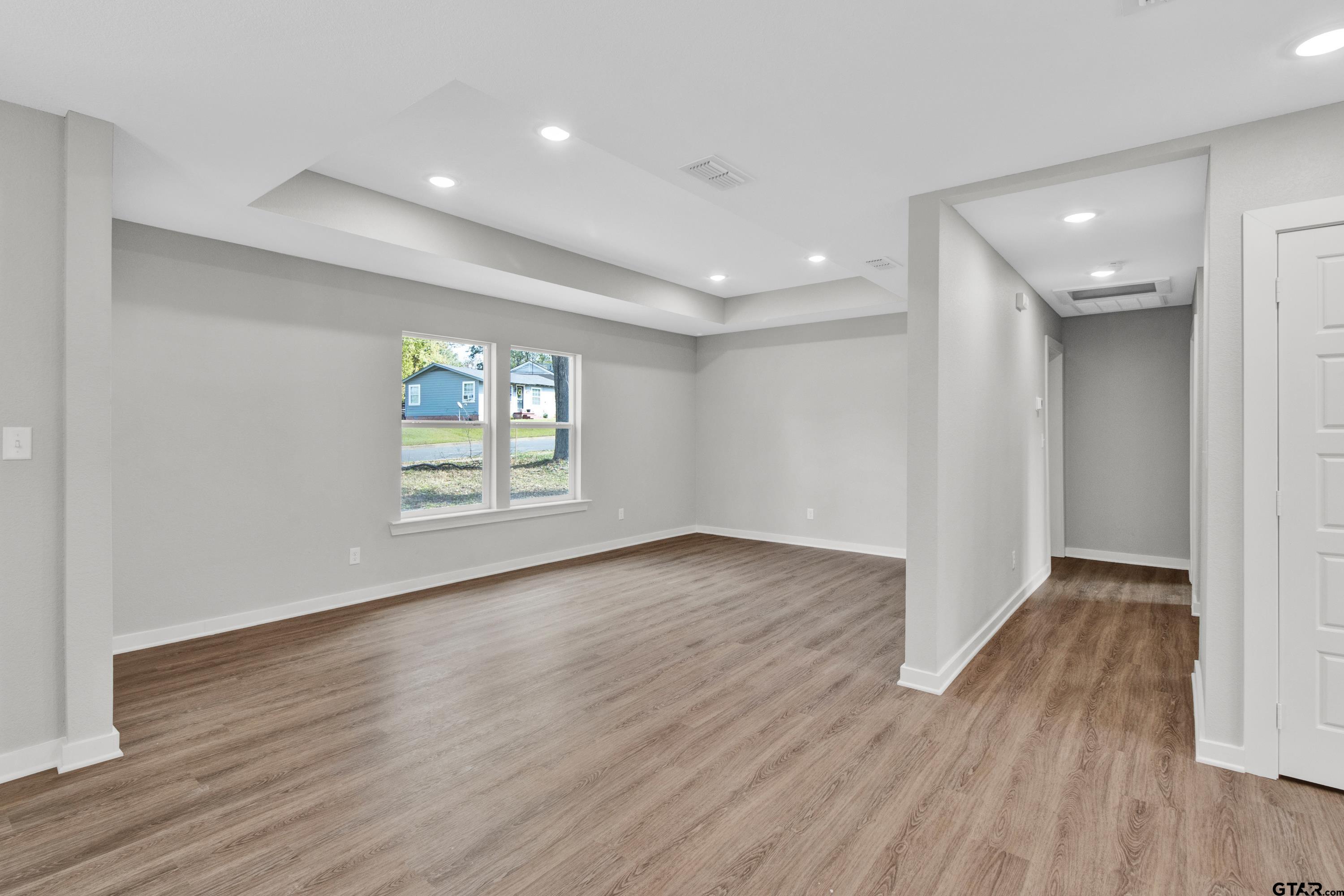 1448 Crescent Drive Tyler, TX 75702 - Photo 11 of 32 a view of an empty room with wooden floor and a window