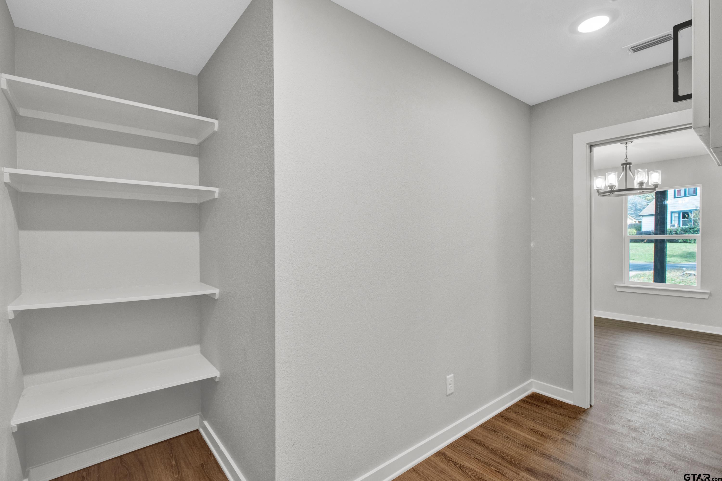 1448 Crescent Drive Tyler, TX 75702 - Photo 17 of 32 a view of an empty room with a window and wooden floor